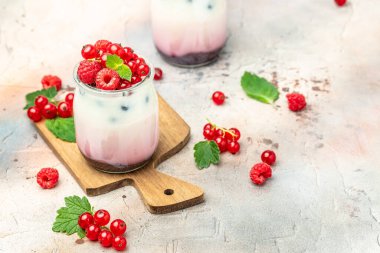 Raspberry dessert cheesecake, trifle, mouse in a glass. Raspberry Greek yogurt granola parfait on a light background. Restaurant menu, dieting, cookbook recipe.