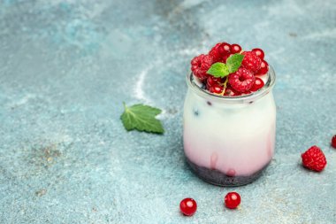 Raspberry dessert cheesecake, trifle, mouse in a glass. Raspberry Greek yogurt granola parfait on a light background. Restaurant menu, dieting, cookbook recipe.