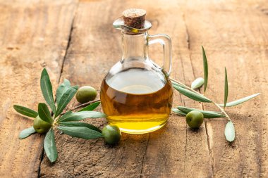 Zeytinyağlı yeşil zeytin. Ahşap arka planda ekstra saf zeytinyağı kavanozları. metin için yer.