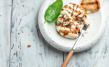 Basil yapraklı burrata peyniri beyaz tabakta, arka planda. Uzun afiş biçimi. en üstteki görünüm.