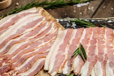 Ahşap bir tahtada domuz pastırması ve biberiye, Keto diyet gıda malzemeleri. Yemek tarifi geçmişi. Kapat..