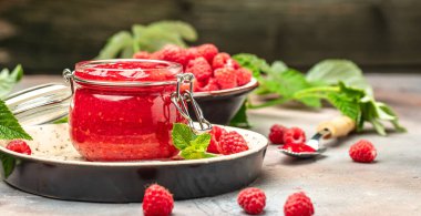 Ev yapımı ahududu reçeli kavanozda ahududu ve nane. Uzun afiş biçimi. metin için yer.