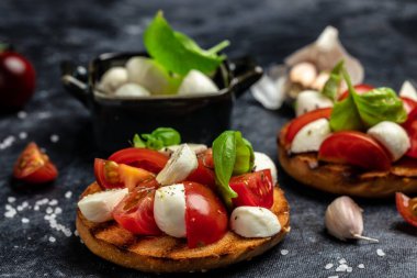 Kiraz domatesli sandviç, mini mozzarella, taze fesleğen yaprağı, ekmek üstü caprese, geleneksel İtalyan aperatifi veya aperatifi, antipasto. afiş, menü, metin için tarif yeri, üst görünüm.