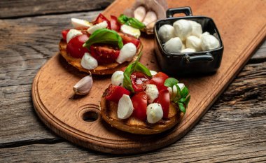 Mozzarella, kiraz domatesli ve taze fesleğenli Caprese tostları. Geleneksel İtalyan aperatifi veya aperatifi, antipasto. afiş, menü, metin için tarif yeri, üst görünüm.