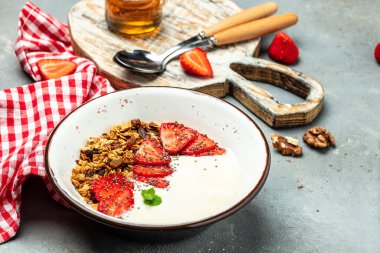 Bir kase ev yapımı granola, taze çilek, chia tohumu ve bal. Lezzetli kahvaltı ya da atıştırmalık. afiş, menü, metin için tarif yeri, üst görünüm.