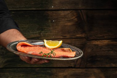 salmon in hands. Chef's hand holding fresh fillet of salmon, banner, menu, recipe place for text,