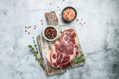 Kesme tahtasındaki çiğ biftekler ve arka planda baharatlar. metin için yer, üst görünüm.