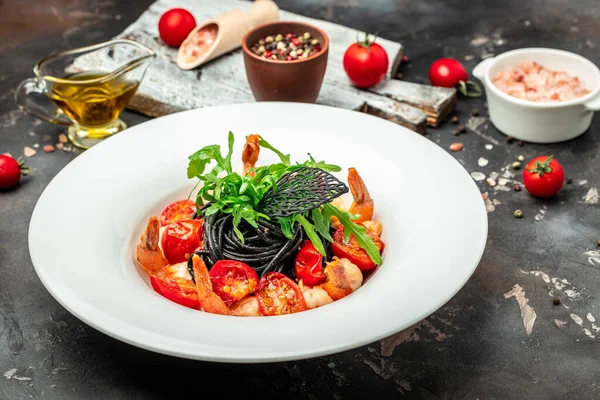 black pasta with shrimp and cherry tomatoes, Food recipe background. Close up, top view,