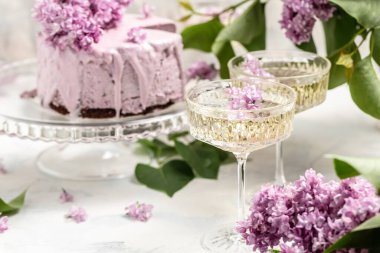 mousse cake blueberry tart. bouquet of purple blooming lilacs, French cuisine, postcard, background.