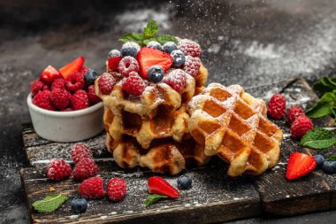 Ahududu, çilek ve yabanmersinli Belçika Waffle 'ı. Mutfak, yemek pişirme, fırın konsepti. Yemek tarifi geçmişi. Kapat..