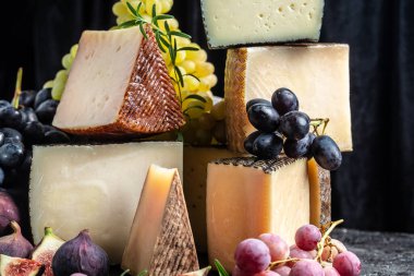 Assortment of different cheese types with grapes and figs. Cheese background. traditional pieces of Spanish, French, Italy cheese. clipart