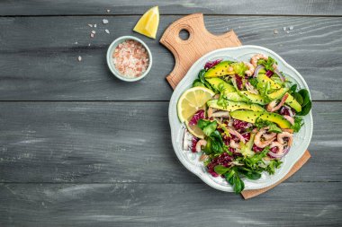 Taze avokado salatası, karides, marul yeşili karışım ve zeytinyağı, limon sosu. Sağlıklı yemek, lezzetli kahvaltı ya da atıştırmalık, temiz yemek, diyet, vejetaryen yemek konsepti. en üstteki görünüm.
