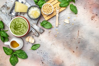 Yeşil pesto çam fıstığı, parmesan ve sarımsaklı İtalyan fesleğeni sosu kasesi. Uzun afiş biçimi. en üstteki görünüm.
