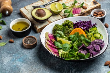 Tatlı patates, brokoli, avokado, mor lahana, salatalık, karpuz turpu ve bademli yeşil sebze salatası. Temiz yemek, diyet yemek konsepti. en üstteki görünüm..