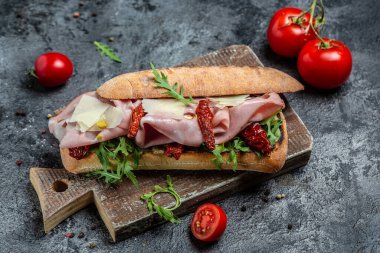 Prosciutto sandviçi, jambonlu Ciabatta, kurutulmuş domatesler, turşu, parmesan ve roka, afiş, menü, metin için tarif yeri.,