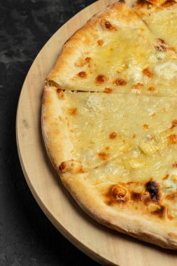 Çedar peynirli pizza, parmesan peyniri, koyu arkaplanda mozzarella. yemek teslimatı, metin yeri, dikey resim,