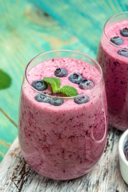 Bilberry yogurt cocktail on a blue background. Natural detox. vertical image. top view. place for text.