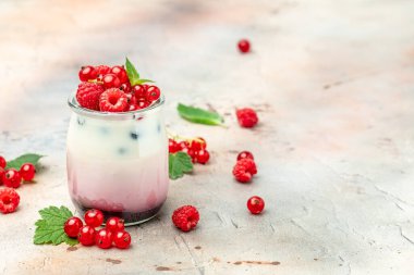 Ahududulu yoğurt. Sağlıklı kahvaltıda Yunan yoğurdu, ahududu ve nane şekeri. Meyveli buzlu içecek. sağlıklı beslenme konsepti.