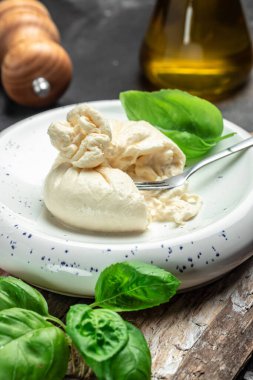 Mozzarella 'dan taze beyaz burrata peyniri ve Apulia' dan krema, İtalyan Akdeniz mutfağı, dikey görüntü. Üst Manzara. metin için yer.