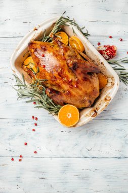 Biberiye ve ahşap zemin üzerinde portakallarla kızarmış Berberli Ördek. dikey görüntü. Üst Manzara. metin için yer,