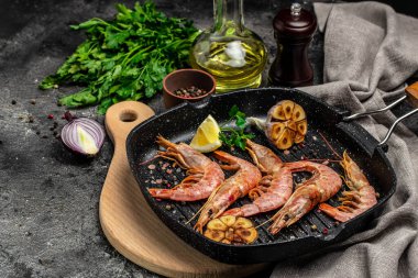 Izgara kaplan karidesi. Koyu bir arka planda dondurulmuş limon suyuyla kızartılmış karidesler. Deniz ürünleri aperatifi. Aşçılık, aşçılık konsepti.