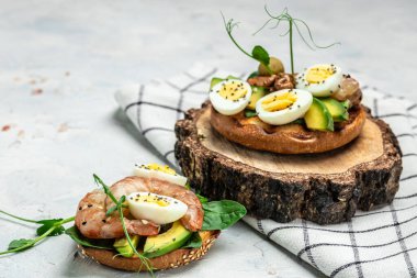 Ekmek, yumurta, ıspanak, avokado, gri arka planda karides, ketogenik kahvaltı. Süper yiyecek konsepti. Sağlıklı beslenme. Üst görünüm.