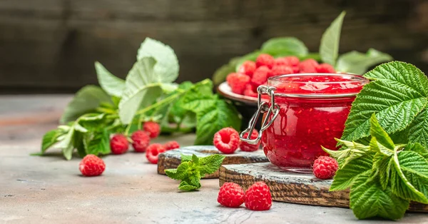 Homemade raspberry jam in jar with raspberries and mint. Long banner format. place for text.