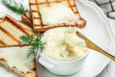 Kahvaltıda krem peynir ve tereyağı. Hafif arkaplanda erimiş peynir. metin için yer.