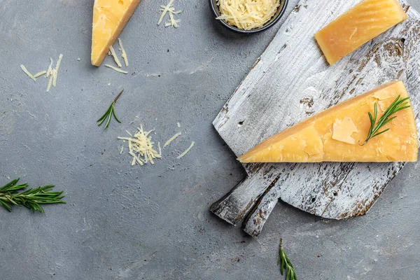 Parmesan cheese with rosemary on a gray table, banner, menu, recipe place for text, top view,
