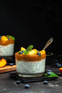 Healthy chia pudding with yogurt and fruit Peach and blueberry. Homemade dessert with fruits. place for text, top view.