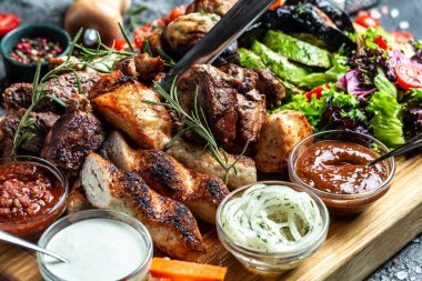 Lezzetli ızgara et ve sebze. Ahşap tabakta ızgara bbq eti ve sebzeler. Restoran menüsü, diyet, yemek kitabı tarifi üst görünümü,