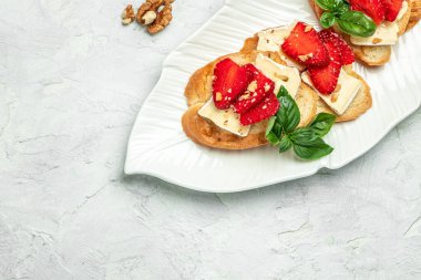 Çilekli crostini, peynirli camembert fındığı ve bal. Uzun afiş biçimi. en üstteki görünüm.