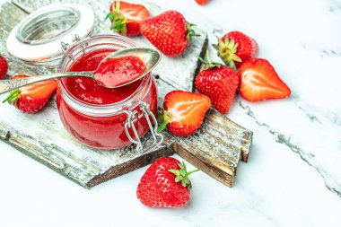 Beyaz arka planda bir kavanoz çilek reçeli. Ev yapımı çilekli marmelat ve meyve. Uzun pankart biçimi.