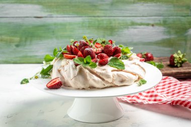 Taze çilek ve kremayla süslenmiş pavlova kremalı pasta. yemek, aşçılık, pişirme ve pişirme konsepti.
