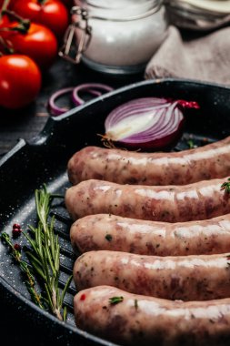 Baharatlı ve biberiyeli çiğ sosis. Yemek malzemesi. Doğal sağlıklı gıda konsepti. en üstteki görünüm.