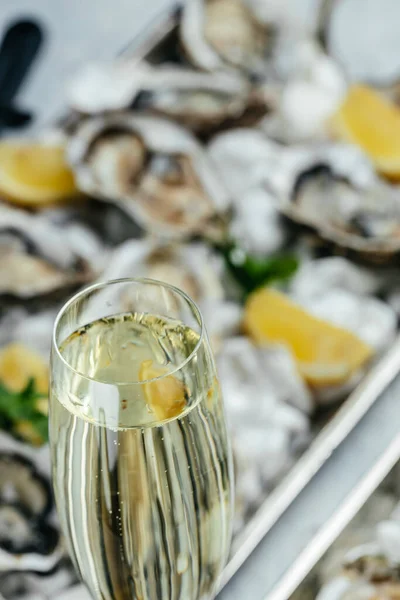 Oysters plate with lemon and champagne in restaurant. Oysters with lemon. vertical image. top view. place for text.