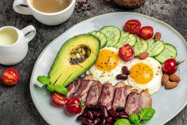 Kahvaltı diyeti avokado, kızarmış yumurta, pastırma, fasulye ve kahve. Yemek tarifi geçmişi. Kapat.,