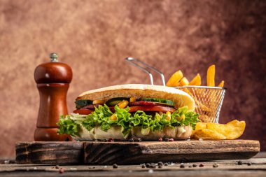 Tavuklu sandviç panini ve ahşap bir tahtanın üzerinde fırında patates. yemek ya da öğle yemeği.