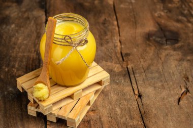 Yağ. Ahşap bir arka planda kavanozda açık bir tereyağı. afiş, menü, metin için tarif yeri.