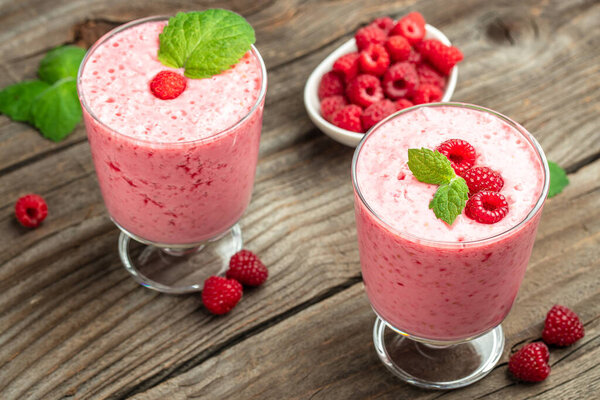 Yogurt smoothie with raspberries in glass on wooden table. weight loss concept. banner, menu, recipe place for text, top view.