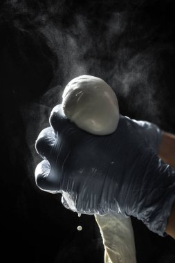 Mozarella peynirinin üretim süreci. Küçük bir aile mandırasında çalışan bir kadın peynir yapmanın son adımlarını işliyor. Geleneksel İtalyan mozzarellası.
