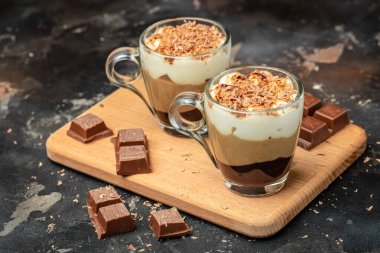 Tahta bir tahtanın üzerinde cam bir kavanozda üç çikolata. Yemek tarifi geçmişi. Kapat..