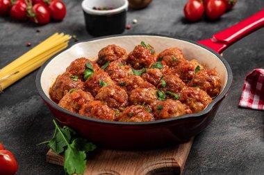 Tatlı ve ekşi domates soslu köfte. Koyu arkaplanda kızartma tavasında,