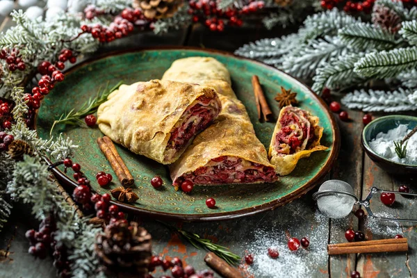 Strudel with a cherry. . winter dessert strudel with cherry, cranberries and walnut. Food recipe background. Close up.