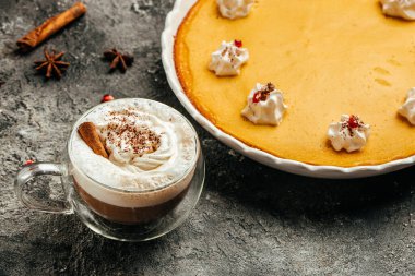 Homemade pumpkin pie cheesecake decorated with whipped cream and latte. Food recipe background. Close up.