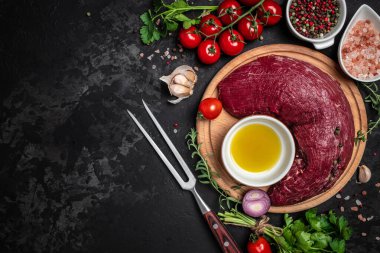 Taze ve çiğ et. Biftek ve baharatlı sığır filetosu koyu arka planda, pankartta, menüde, metin için yemek pişirmeye hazır.,