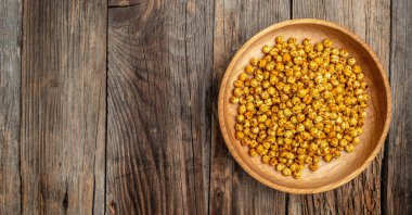 Geleneksel Hint mutfağı. Ahşap arka planda kızarmış baharatlı nohut, uzun afiş formatında. en üstteki görünüm,