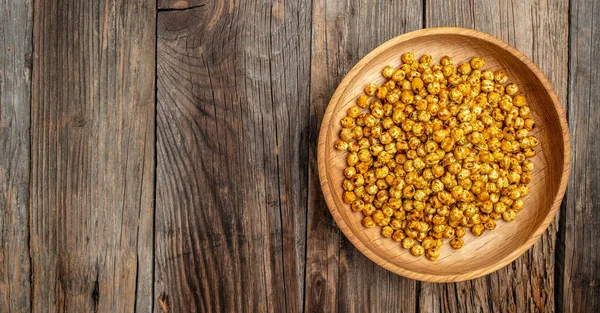 Geleneksel Hint mutfağı. Ahşap arka planda kızarmış baharatlı nohut, uzun afiş formatında. en üstteki görünüm,