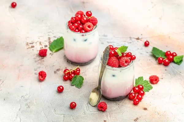 Raspberry dessert cheesecake, trifle, mouse in a glass. Raspberry Greek yogurt granola parfait on a light background. Restaurant menu, dieting, cookbook recipe.