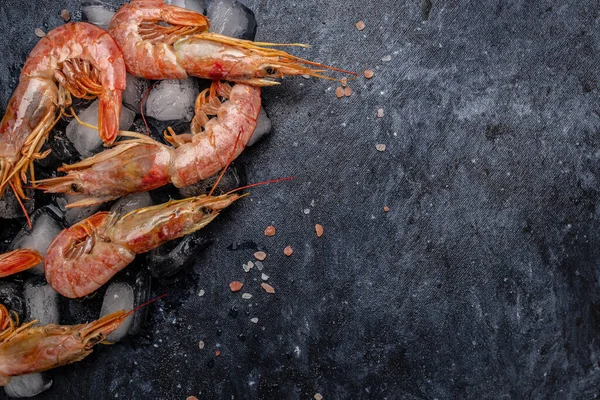 Seafood. Red Argentine shrimps with salt and lemon, Wild shrimps, ocean jumbo shrimps on a dark background. banner, menu, recipe place for text, top view.